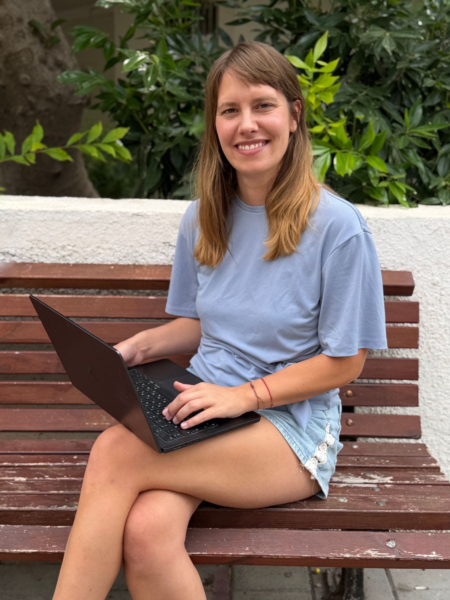 Lola mit Laptop auf einer Bank in Tel Aviv